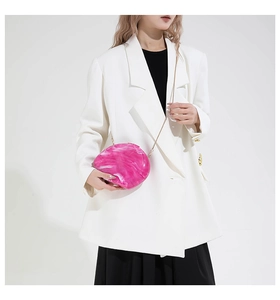 Detailed close-up of pink marble pattern acrylic clutch with gold metal chain strap