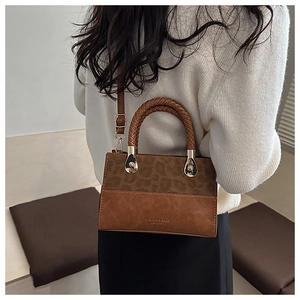 Detail of trendy leopard print stitching on a brown leather crossbody bag with woven handle