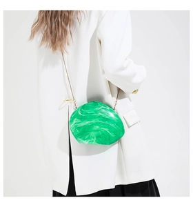 Detail of the emerald marble pattern and golden chain on this oval acrylic clutch bag