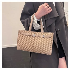 Détail du sac cabas tissé beige avec garniture en cuir et boucle métallique