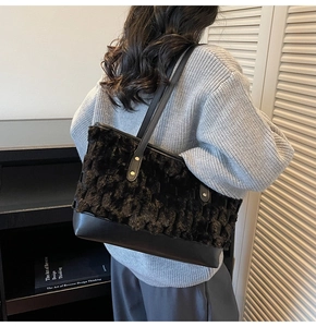 Detail of black faux fur tote bag with wavy texture and smooth leather shoulder strap