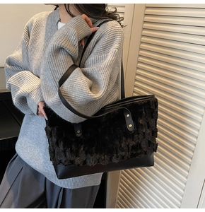 Detail of contrast bucket bag featuring black faux fur top and smooth leather base