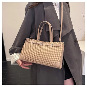 Détail du sac cabas beige à motif pied-de-poule avec brides en cuir et boucles métalliques