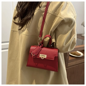 Borsa Kelly rossa in pelle martellata con chiusura dorata in un ambiente domestico