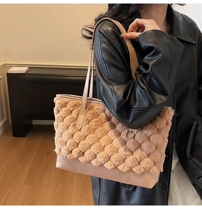 Detail showing the textured camel faux fur material and smooth leather straps of the tote bag