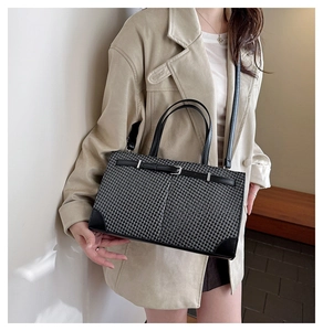 Détail du sac cabas pied-de-poule avec finitions cuir et boucle argent sur mannequin