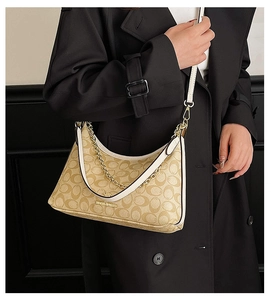 Détail du sac hobo montrant le motif signature, la chaîne dorée et la bandoulière