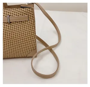 Détail de la texture tissée et de la bandoulière en cuir d'un sac cabas vintage avec boucle