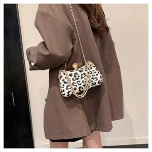Detail of leopard print handbag with golden chain and oversized pearl clasp closure