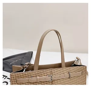 Détail d'un sac cabas tissé beige avec anses en cuir marron et boucle en argent