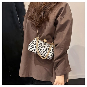 Detailed view of leopard print crossbody bag with pearl clasp and gold chain straps