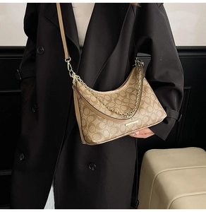 Détail du sac hobo vintage avec chaîne dorée et bandoulière en cuir sur modèle