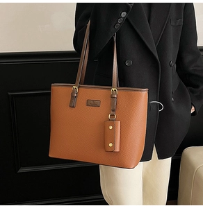 Detail of vintage brown lychee grain tote bag with gold hardware and small accessory pouch