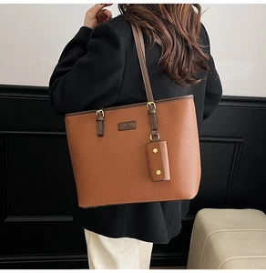 Detail of a brown lychee pattern leather tote bag with gold buckle and mini coin purse