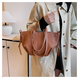 Detailed view of brown litchi grain tote bag with drawstring accents and dual straps