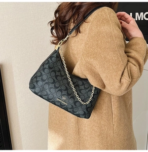Détail du sac hobo noir à motif vintage avec logo kangourou doré et bandoulière