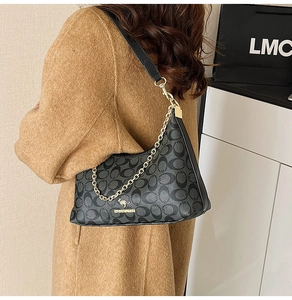 Détail du sac vintage à chaîne avec motif monogramme gris et logo kangourou doré