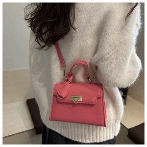 Rosa Mini-Tasche mit Litschistruktur, goldenem Drehverschluss und feinem Schultergurt