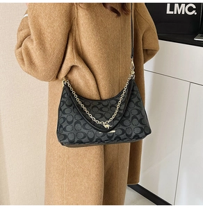 Détail du sac à bandoulière monogramme noir avec logo kangourou doré et chaîne en métal