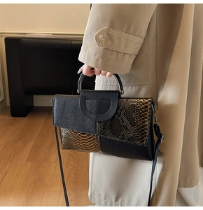 Detail of snake pattern stitching and metal U-shaped buckle on a luxury clutch bag
