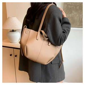Close-up of beige lychee pattern leather tote bag shown in a cozy home setting