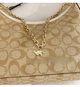 Gros plan sur le motif monogramme vintage avec chaîne dorée et pendentif kangourou