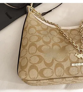Détail du sac hobo avec motif monogramme en toile et bandoulière chaîne dorée