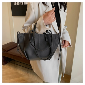 Détail du sac cabas noir grainé avec surpiqûres blanches et décor de cordon de serrage