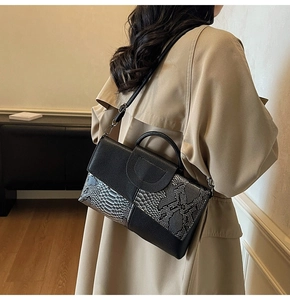 Detail of snake pattern textured handbag worn with a trench coat for a stylish look