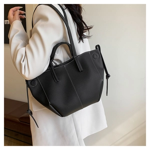 Detail of black textured leather tote with contrast white stitching and side drawstring