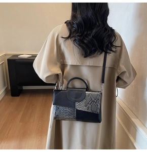 Detail showing snake pattern embossed patchwork design on an elegant women's handbag
