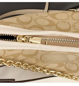 Détail de la fermeture éclair dorée et imprimé vintage C sur le sac hobo élégant
