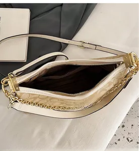 Détail intérieur du sac à bandoulière à motifs avec doublure rayée et poche zippée