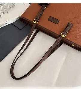 Detail of caramel tote bag showing lychee grain leather texture and gold hardware buckle
