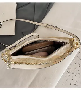 Vue intérieure montrant la grande capacité et le zip de ce sac bandoulière beige imprimé