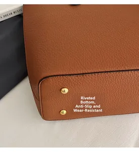 Close-up of brown lychee grain leather bag base with protective gold metal studs