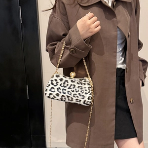 Women's leopard print box bag with gold chain and pearl clasp worn with brown coat