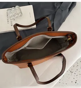 Top view of brown leather tote bag showing large interior space and inner zip pocket
