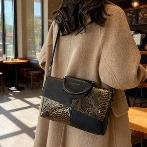 Chic snakeskin textured patchwork handbag for women with black leather strap on camel coat
