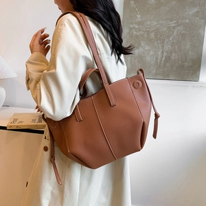 Brown litchi pattern leather tote bag with white stitching and drawstring details