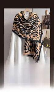 Detail of leopard and tiger print winter scarf showing thick faux cashmere texture and fringe
