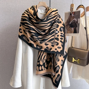 Detail of leopard print thick shawl with handmade label and fringe on white coat