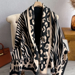 Detail of leopard and zebra print patchwork scarf with fringe and soft cashmere-like texture