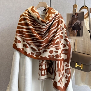 Detail of animal print cashmere-feel scarf showing leopard pattern and handmade tag