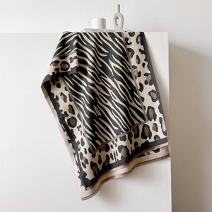 Detail of leopard and zebra print shawl with soft fringed edges on a white display