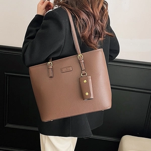 Retro large brown pebble leather tote bag with gold hardware shown on a model