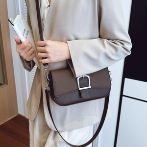 Sac bandoulière en cuir marron avec boucle argentée porté avec un blazer beige chic
