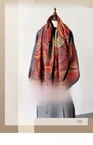 Detailansicht eines Vintage-Boho-Schals auf einem grauen Wollmantel für den Winter