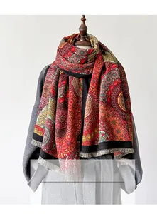 Detail eines roten Boho-Schals mit Kaleidoskop-Muster und grauen Fransen an einer Schaufensterpuppe