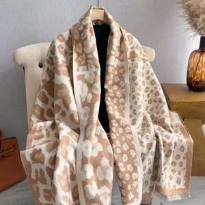 Detailed macro view of soft leopard print jacquard scarf texture with delicate fringe